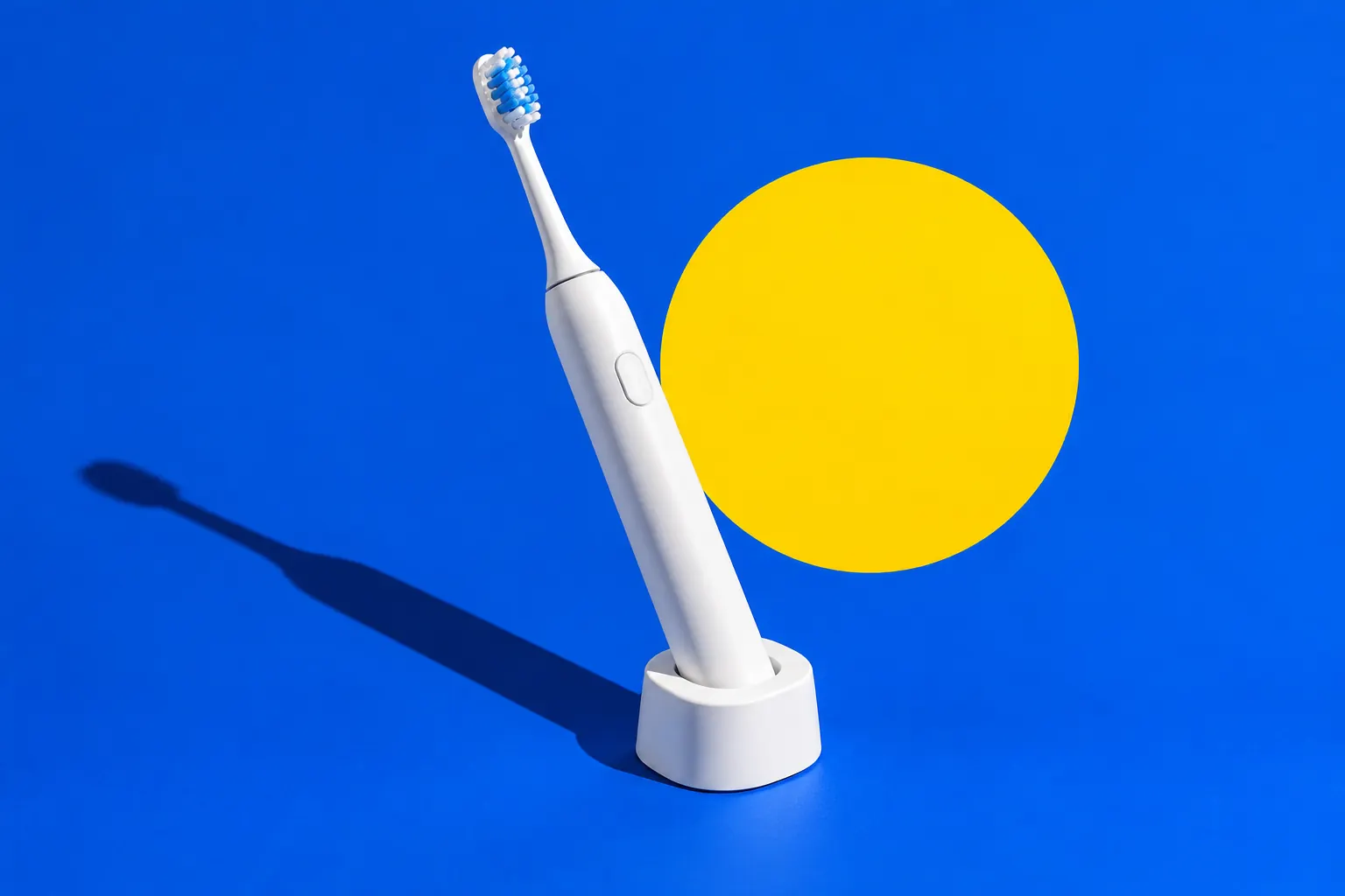 Sfeerbeeld: witte elektrische tandenborstel in een lader voor een kobaltblauw vlak met gele cirkel